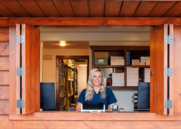 A member of the Sherman Oaks Veterinary Group team at the hospital's wooden pharmacy pick-up window.